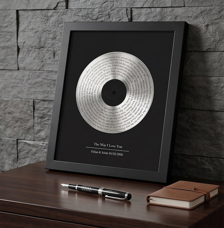 Framed vinyl record with text on a wooden surface against a stone wall background