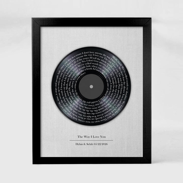 Framed vinyl record with engraved text on a white background