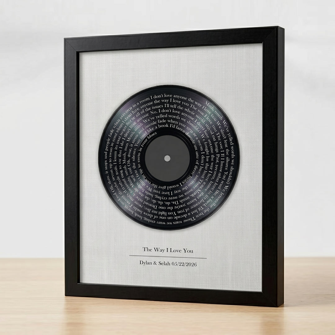 Framed vinyl record with engraved text on a white background