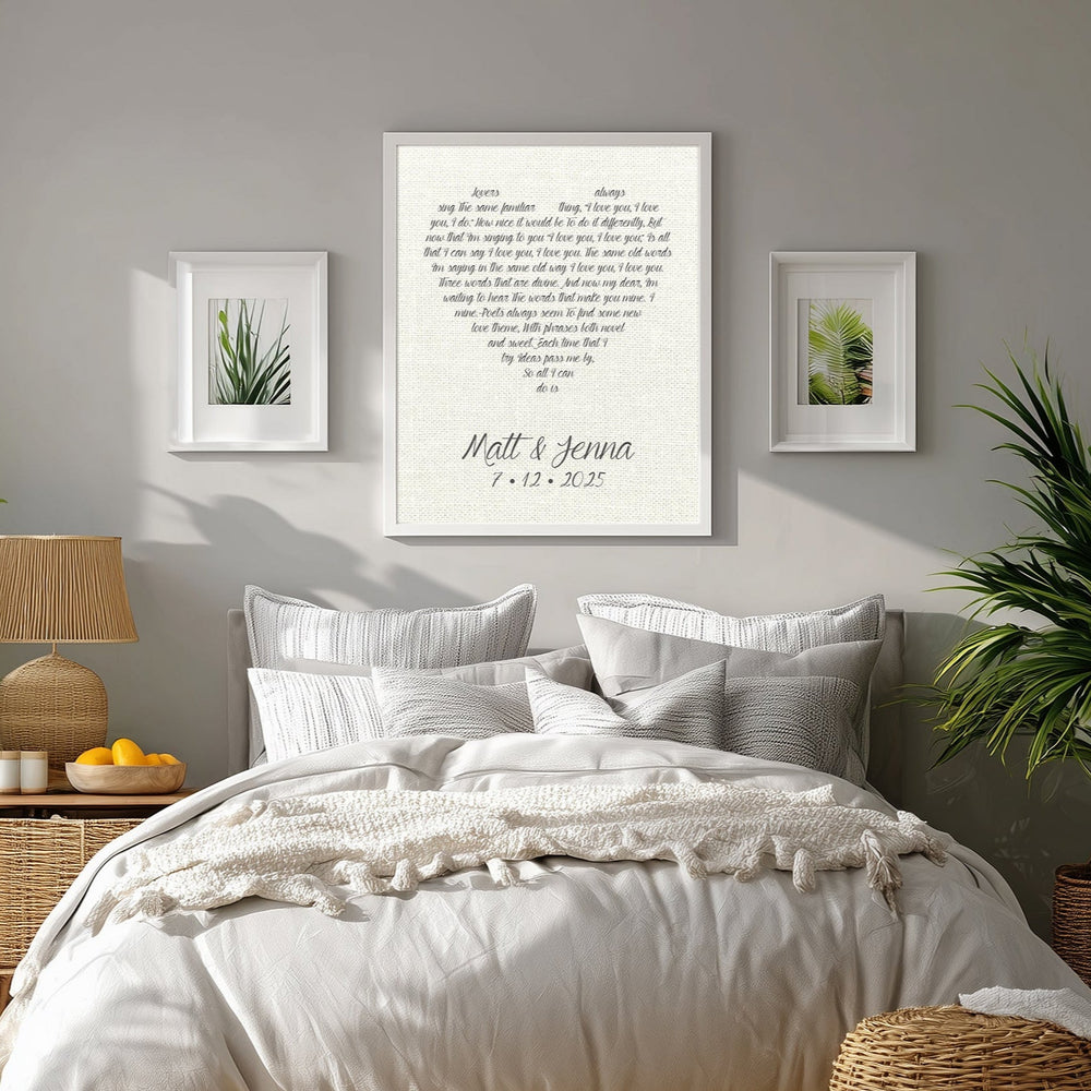 Linen anniversary print above a neatly made bed in a bedroom with plants and decor