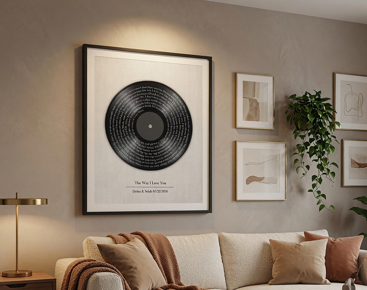 Framed vinyl record on a wall above a sofa with decorative pillows