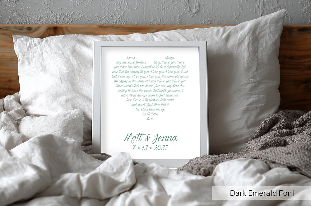 Personalized emerald framed print on a bed with white pillows and bedding.