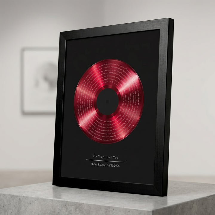 Framed red vinyl record with lyrics on a black surface