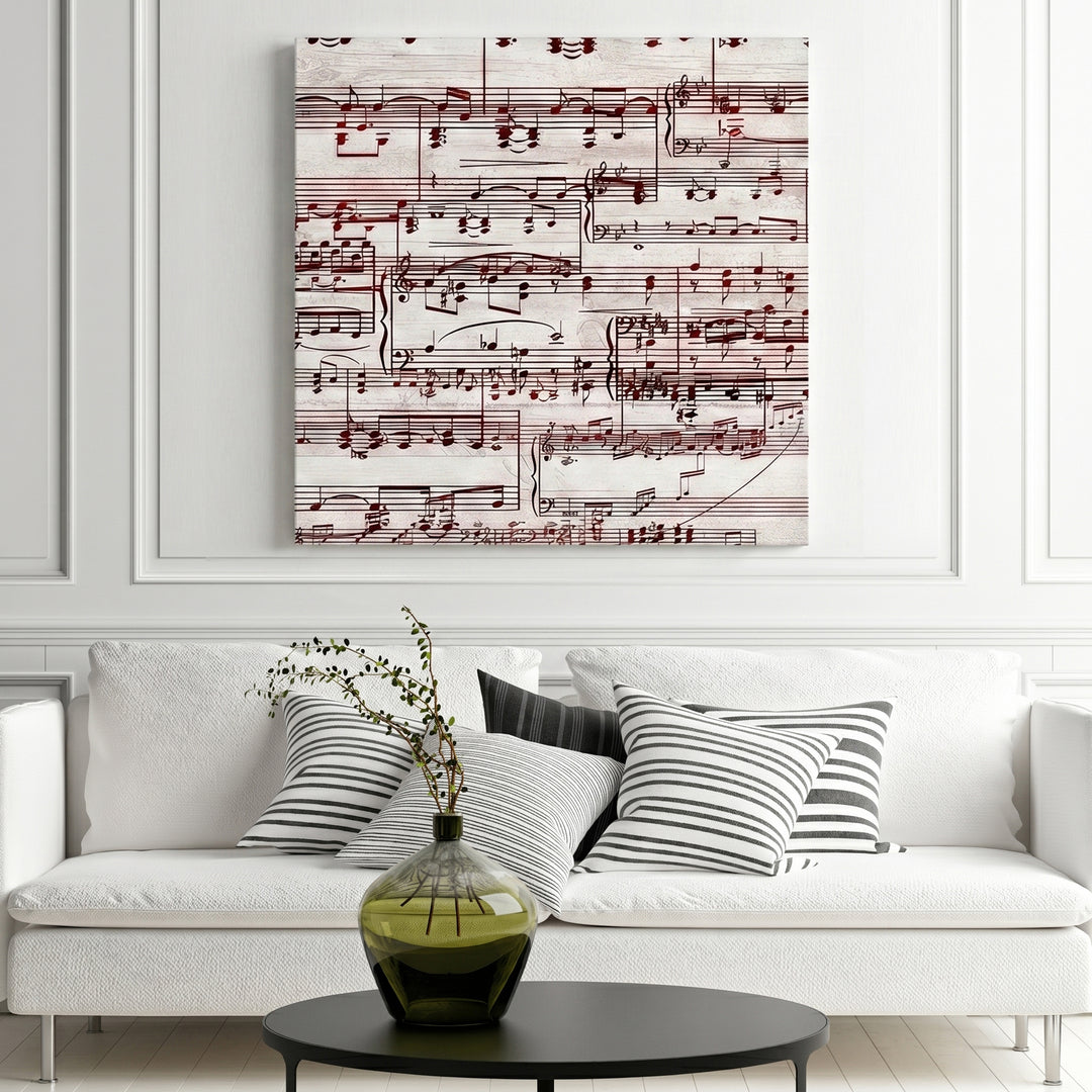 Music sheet design artwork on a wall above a white sofa with striped cushions.