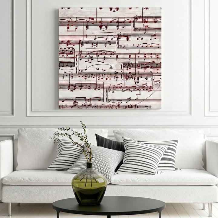 Music sheet design artwork on a wall above a white sofa with striped cushions.