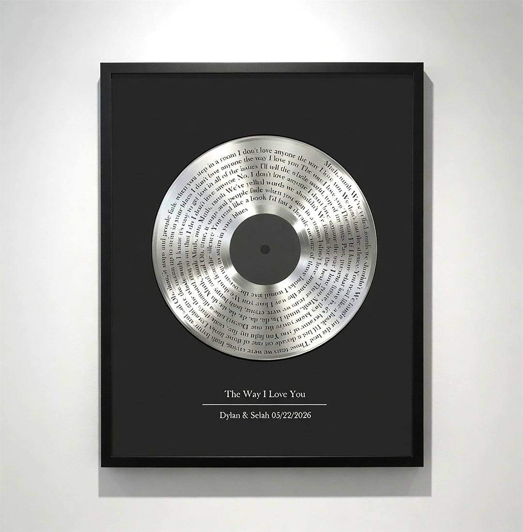 Framed vinyl record with engraved text on a white wall