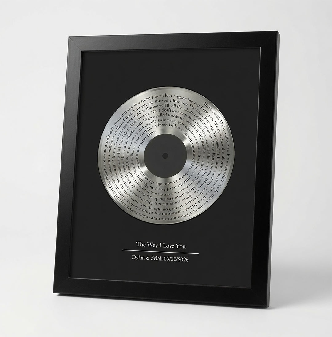 Framed tin vinyl record with engraved text on a white background