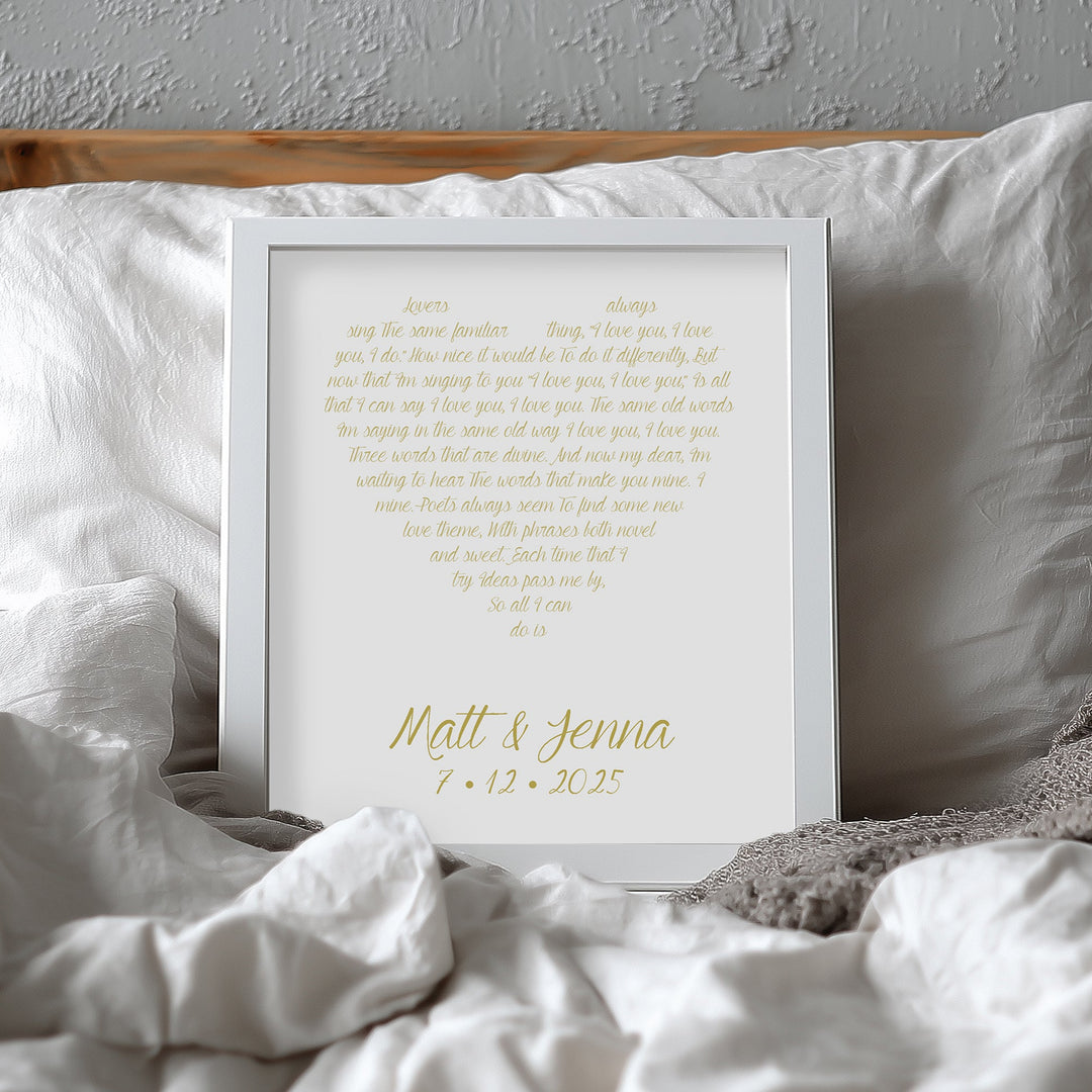 Custom yellow anniversary print with text on a bed with white pillows and gray blanket
