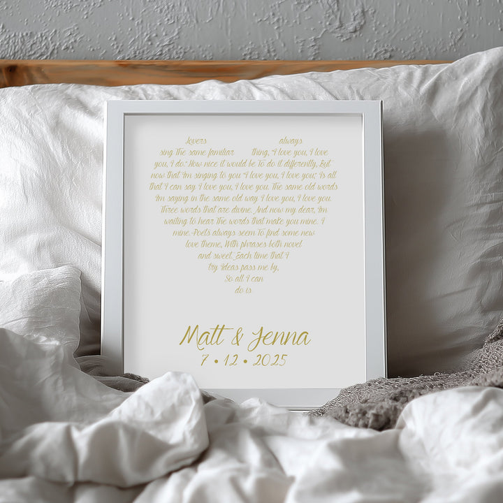 Custom yellow anniversary print with text on a bed with white pillows and gray blanket